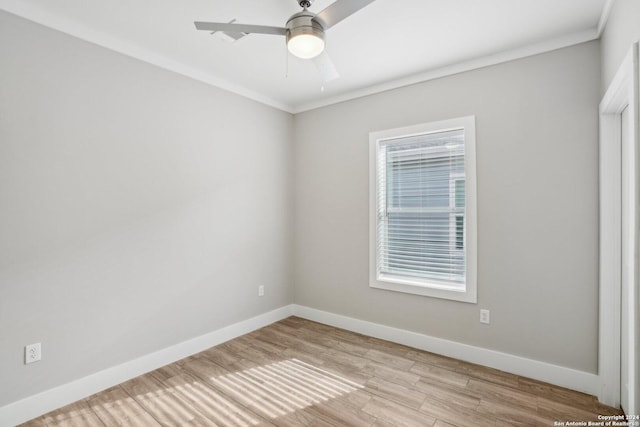 spare room featuring ceiling fan, plenty of natural light, ornamental molding, and light wood-type flooring