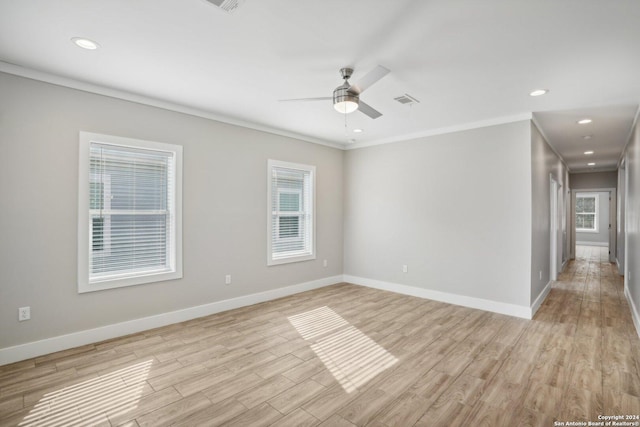 empty room with ornamental molding, ceiling fan, and light wood-type flooring