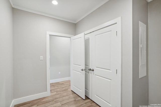 hallway featuring crown molding and light wood-type flooring