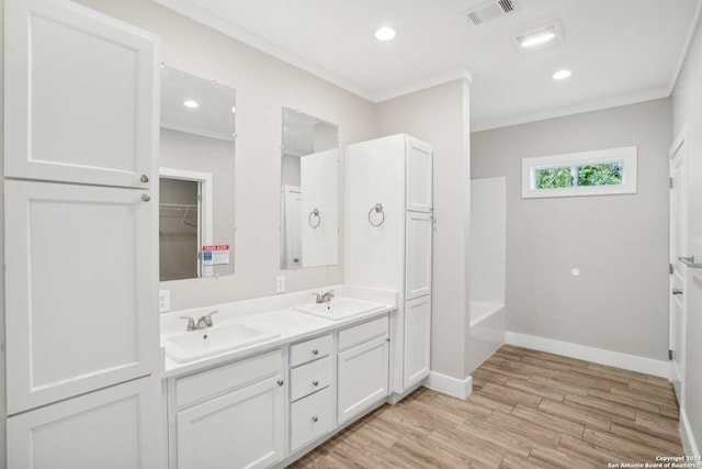 bathroom with vanity, hardwood / wood-style flooring, ornamental molding, and bathtub / shower combination