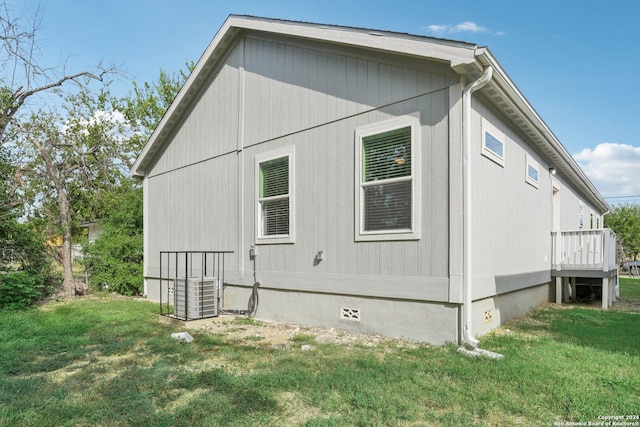 view of side of property with a yard and central AC unit