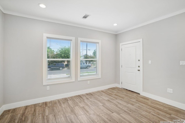 unfurnished room featuring crown molding and light wood-type flooring