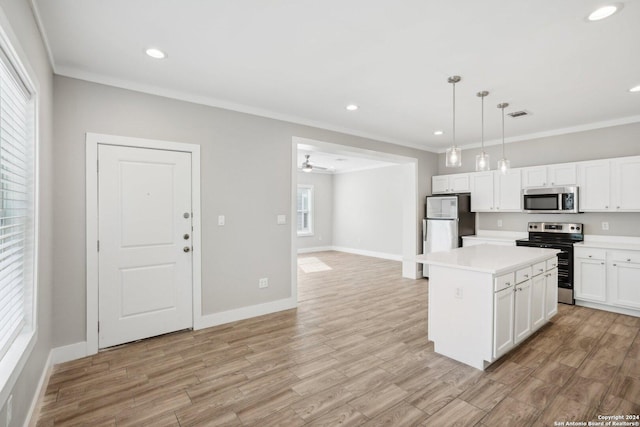 kitchen featuring appliances with stainless steel finishes, white cabinets, hanging light fixtures, a center island, and crown molding