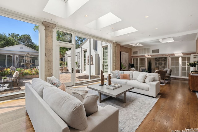 living room with french doors, a wall of windows, wood-type flooring, and a skylight