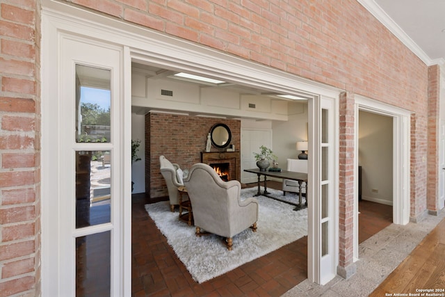 living room with ornamental molding and brick wall