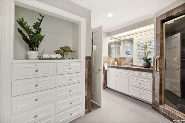 bathroom featuring tile patterned flooring, vanity, crown molding, and walk in shower