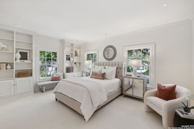 bedroom with ornamental molding and light colored carpet