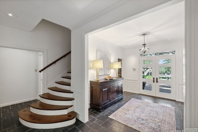 foyer entrance with crown molding and french doors