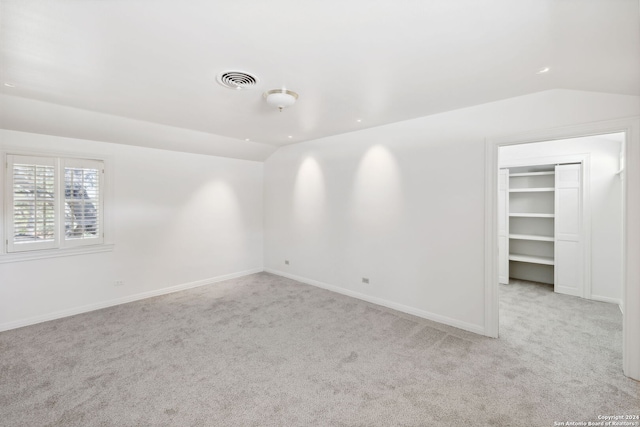 empty room with lofted ceiling and light carpet