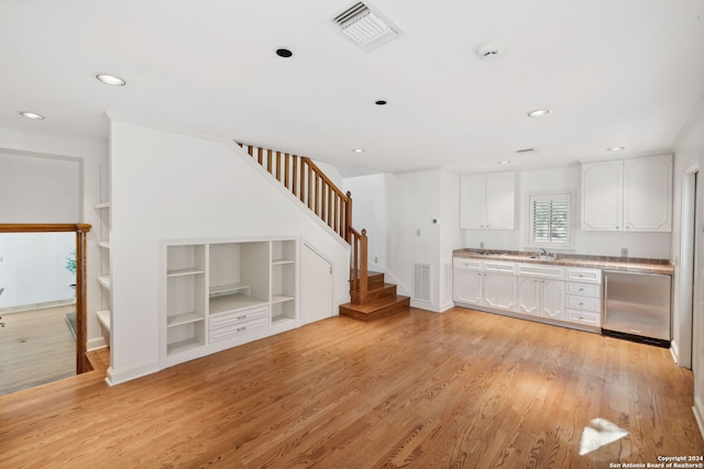 kitchen with dishwasher, sink, light hardwood / wood-style flooring, and white cabinets