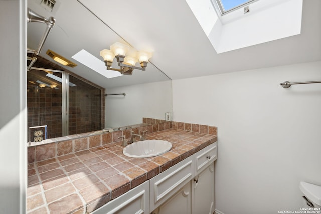 bathroom with vanity and vaulted ceiling with skylight