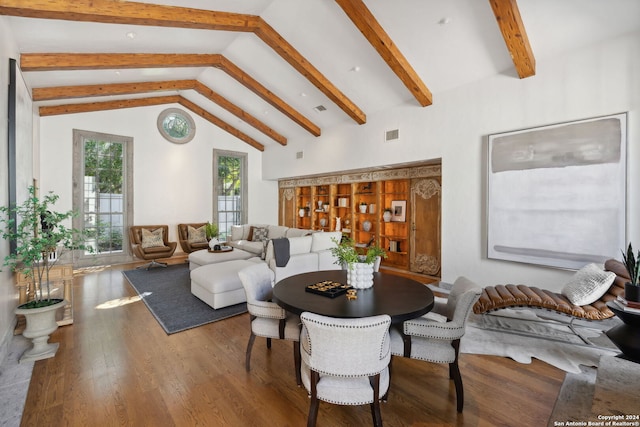 dining space with wood-type flooring and vaulted ceiling with beams