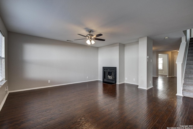 unfurnished living room with dark wood-type flooring and ceiling fan