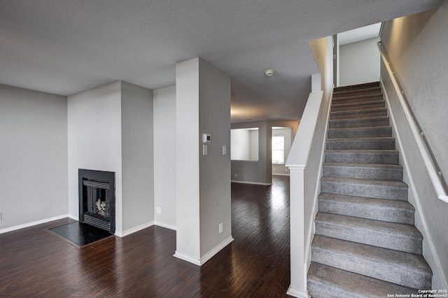 stairway featuring wood-type flooring and a textured ceiling