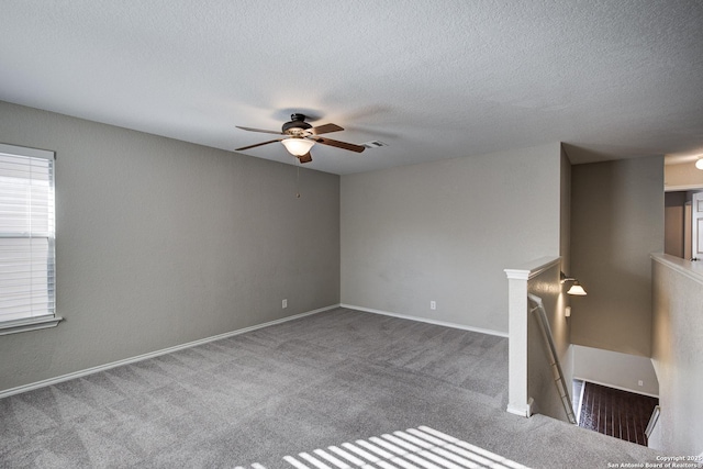 unfurnished room featuring ceiling fan, a textured ceiling, and carpet flooring