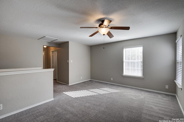 spare room with ceiling fan, a textured ceiling, and dark colored carpet