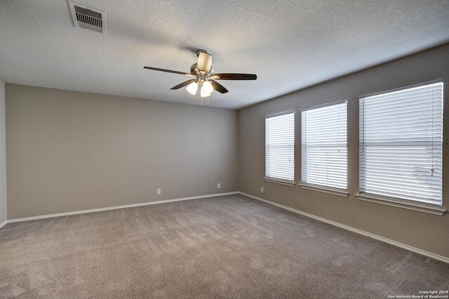 empty room with a textured ceiling, ceiling fan, and carpet