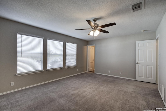 spare room featuring ceiling fan, a textured ceiling, and carpet flooring