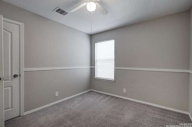 carpeted empty room with ceiling fan and a textured ceiling