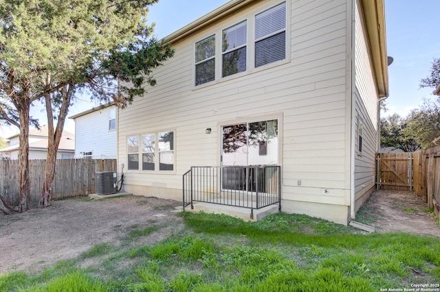 back of house with a lawn and central air condition unit