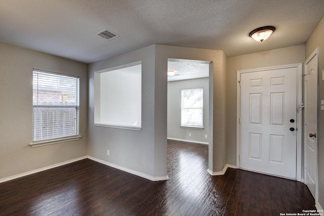 foyer with dark hardwood / wood-style flooring and a textured ceiling