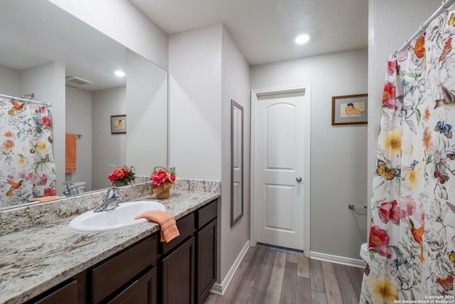 bathroom with vanity, wood-type flooring, and toilet