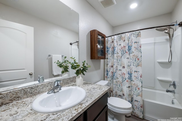 bathroom with visible vents, vanity, toilet, and shower / tub combo