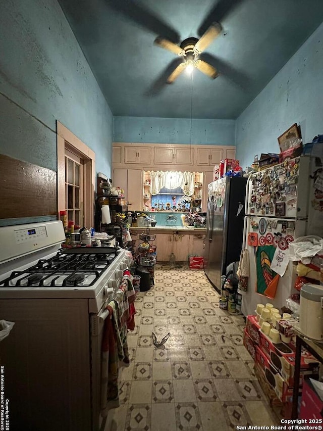 kitchen with ceiling fan, stainless steel fridge, refrigerator, and white range with gas stovetop