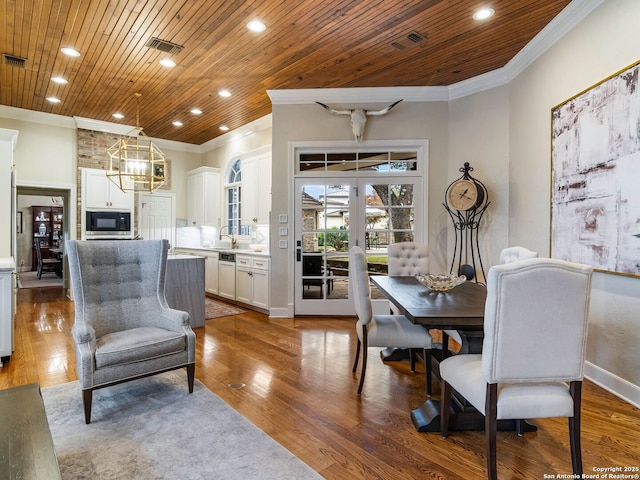 dining area featuring crown molding, wood-type flooring, sink, and wooden ceiling