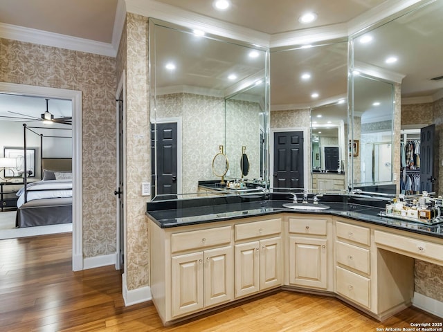 bathroom featuring vanity, hardwood / wood-style flooring, ornamental molding, and ceiling fan