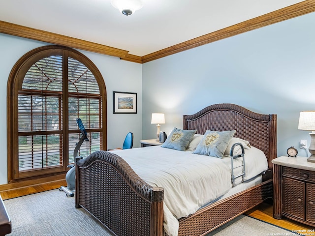 bedroom featuring ornamental molding and light wood-type flooring