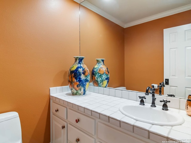 bathroom with vanity, ornamental molding, and toilet