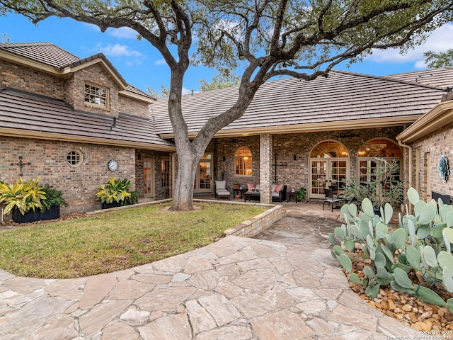 view of front of home featuring french doors, a patio, and a front yard