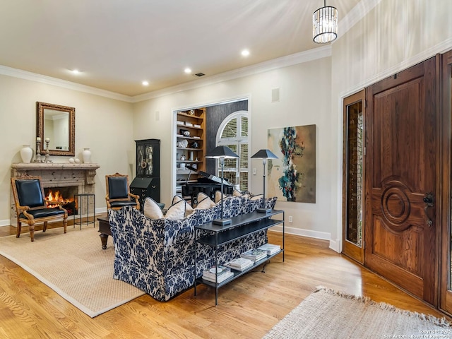 living room featuring an inviting chandelier, ornamental molding, and light wood-type flooring