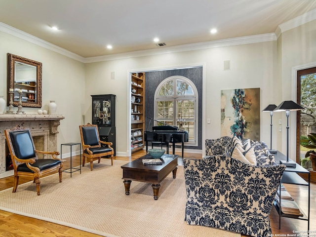 living room featuring ornamental molding, a healthy amount of sunlight, and light hardwood / wood-style flooring