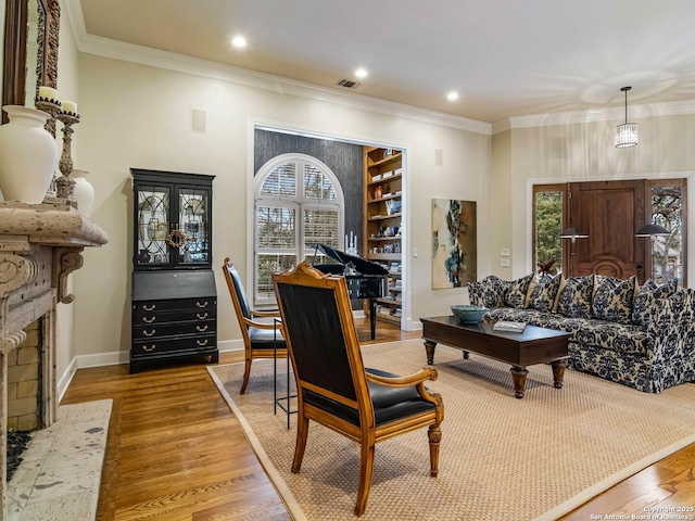 living area with ornamental molding and hardwood / wood-style floors