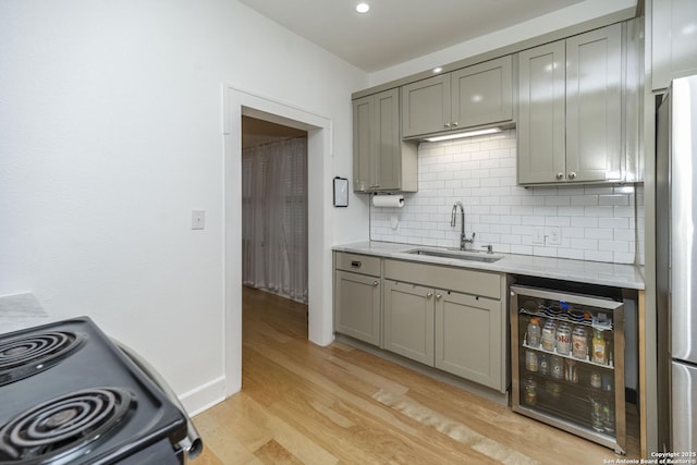 kitchen featuring sink, black electric range oven, wine cooler, tasteful backsplash, and light hardwood / wood-style floors