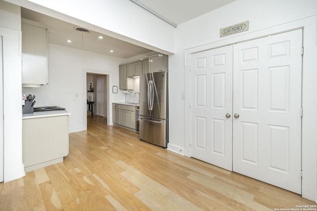 kitchen featuring gray cabinetry, sink, stainless steel fridge, and light hardwood / wood-style floors