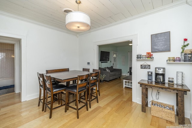 dining space with wood ceiling, light hardwood / wood-style flooring, and ornamental molding