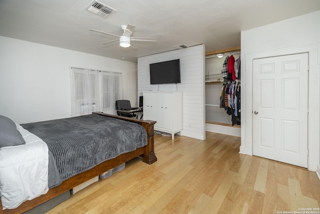 bedroom featuring a spacious closet, hardwood / wood-style floors, a textured ceiling, and a closet