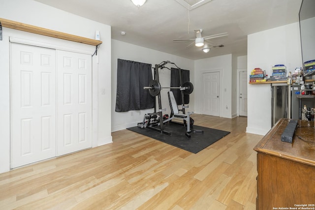 exercise room with ceiling fan and light hardwood / wood-style floors