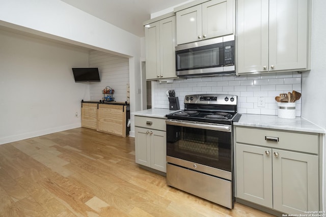 kitchen featuring tasteful backsplash, stainless steel appliances, and light hardwood / wood-style flooring