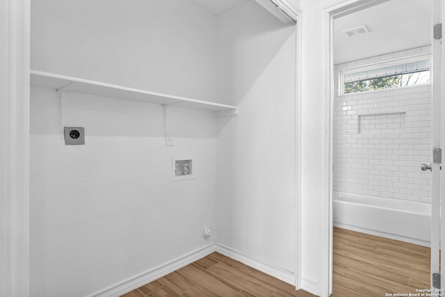 laundry area featuring wood-type flooring, hookup for a washing machine, and electric dryer hookup