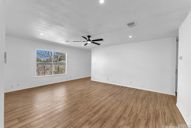 empty room featuring ceiling fan, a textured ceiling, and light wood-type flooring