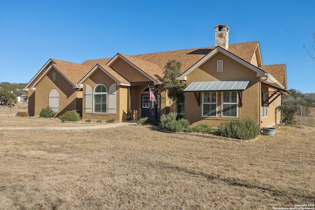 view of front of property with a front yard and solar panels