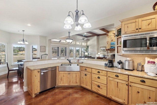 kitchen featuring sink, light stone counters, pendant lighting, stainless steel appliances, and backsplash