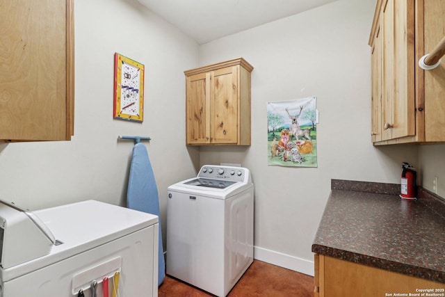 clothes washing area featuring cabinets and separate washer and dryer