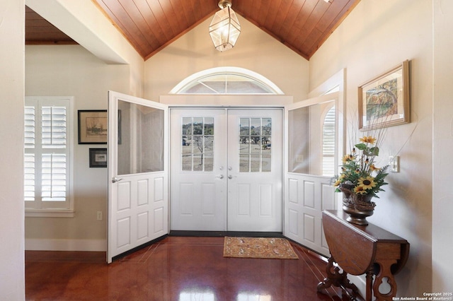 foyer featuring lofted ceiling, dark wood-type flooring, wooden ceiling, and french doors