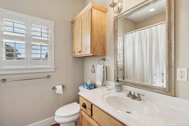 bathroom with vanity, a healthy amount of sunlight, and toilet