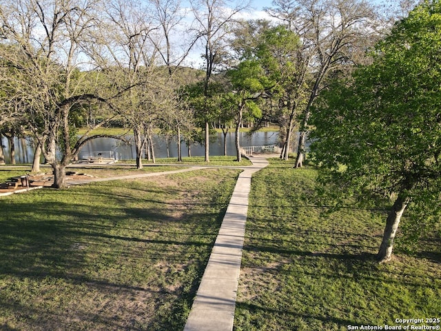 view of home's community with a lawn and a water view